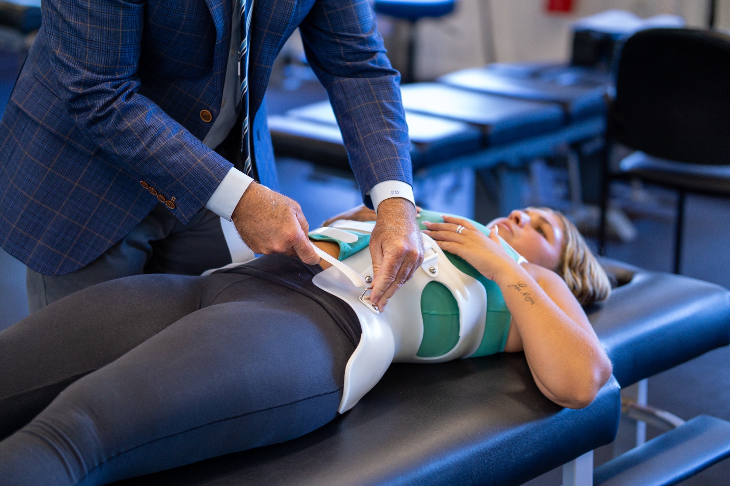 Close view of a specialist securing a custom scoliosis brace
