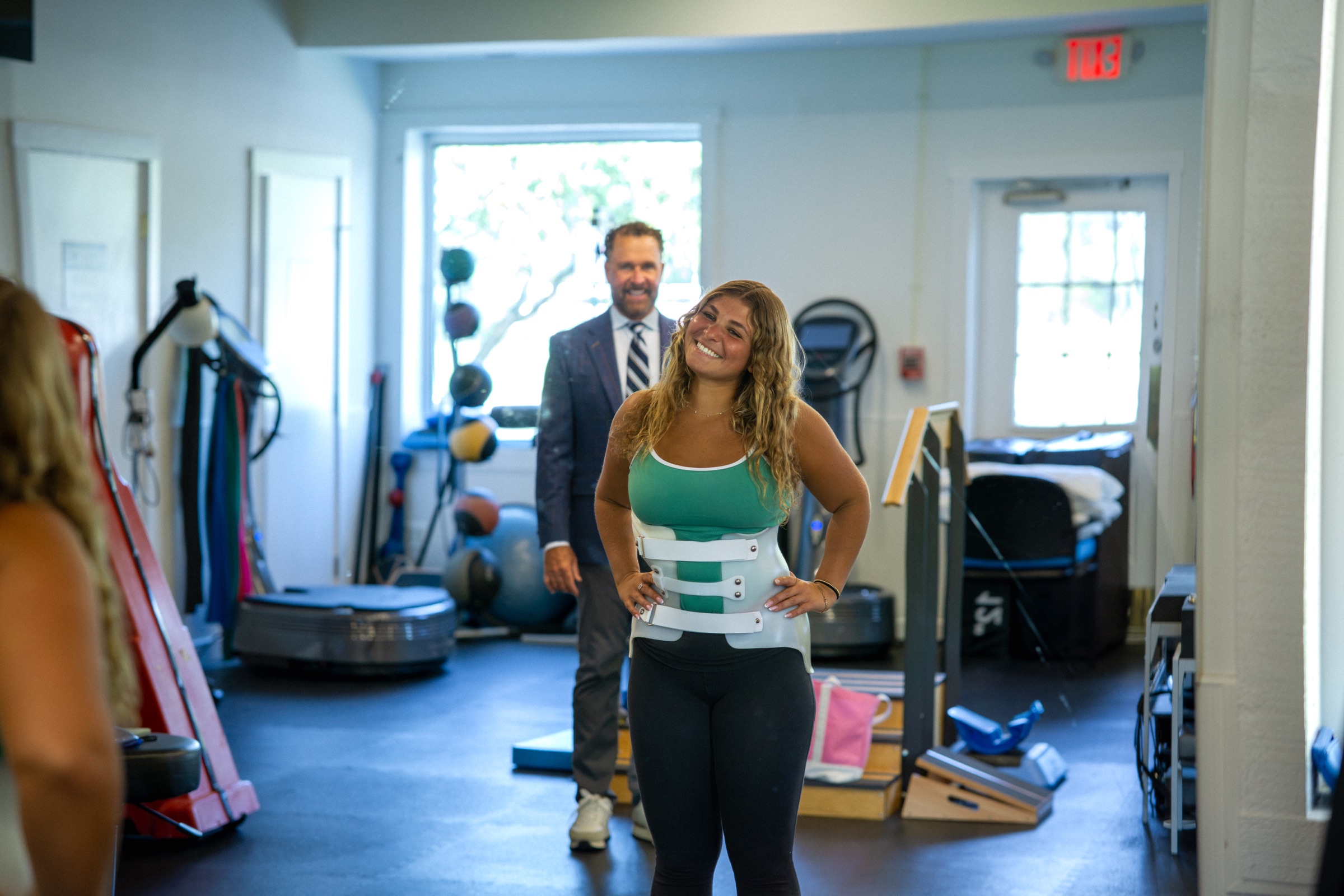 Patient smiling confidently in a custom scoliosis brace